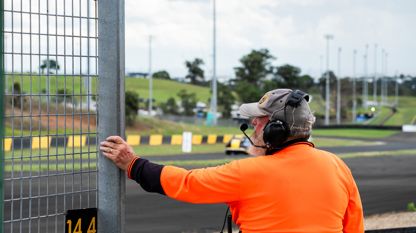 Flag marshall watching the on track action as a storm passes by in the background